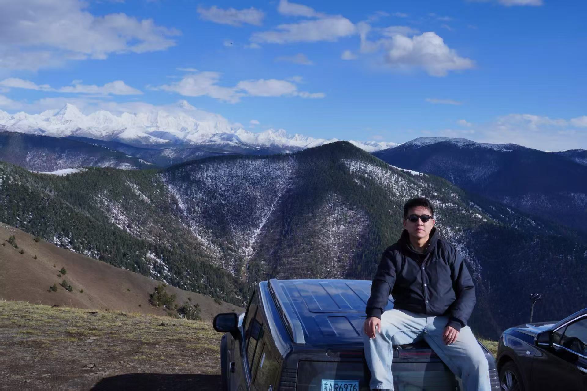 Tianxiang Liang in front of snow-covered mountains